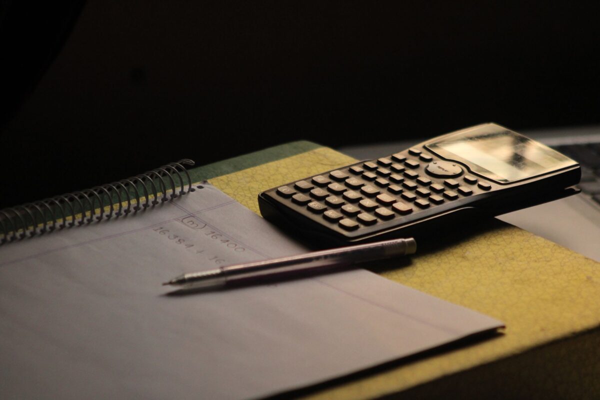 Calculadora y cuaderno sobre un escritorio, ideales para pensar cuánto sale una sesión de terapia