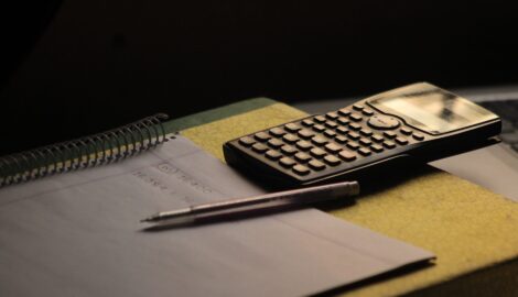 Calculadora y cuaderno sobre un escritorio, ideales para pensar cuánto sale una sesión de terapia