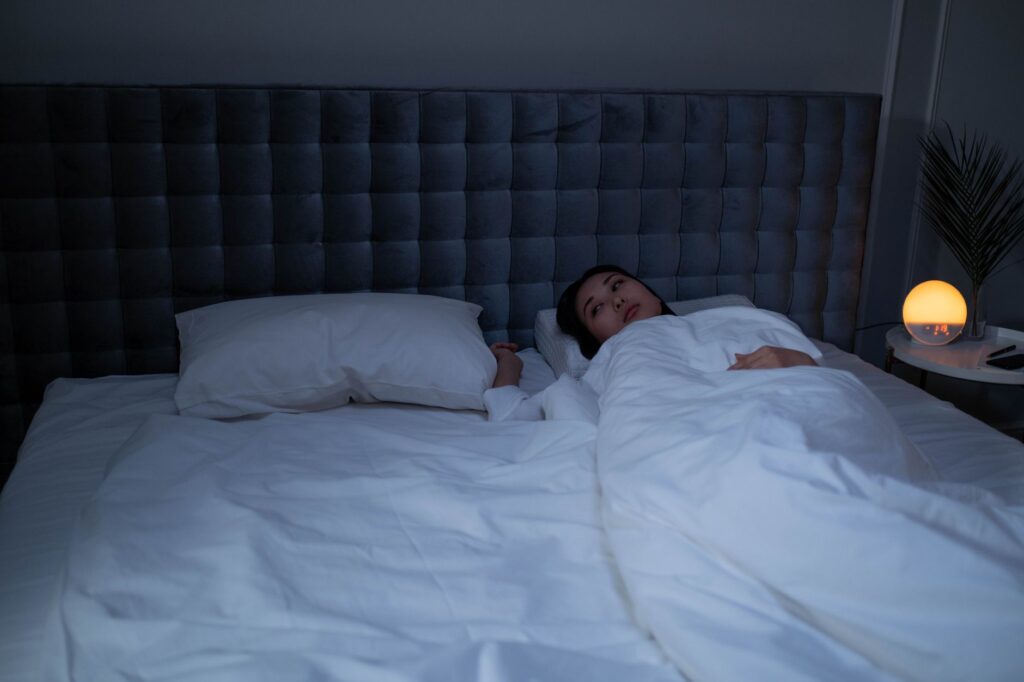 Persona despierta en la cama, de noche, sin poder dormir