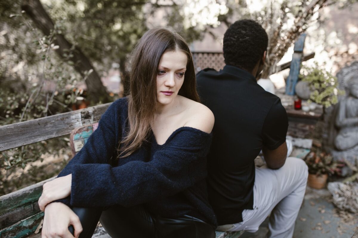 Una pareja sentada, con distancia entre ellos