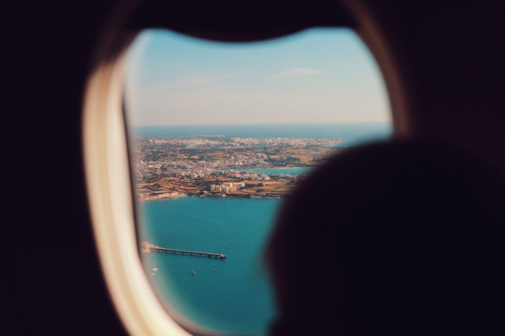 Persona mirando por la ventanilla de un avión con gesto de tensión